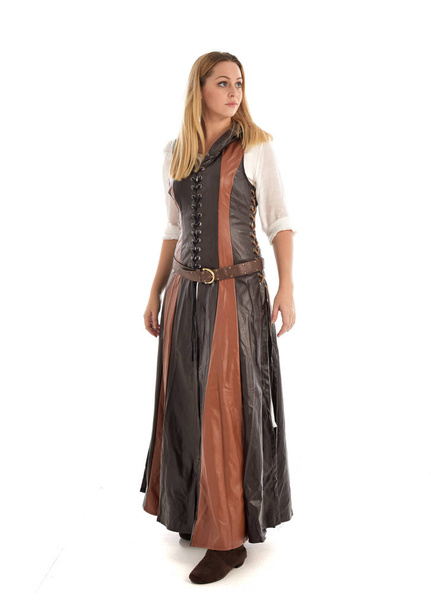 full length portrait of girl wearing brown leather medieval costume, standing pose, isolated on white studio background. - Photo, Image