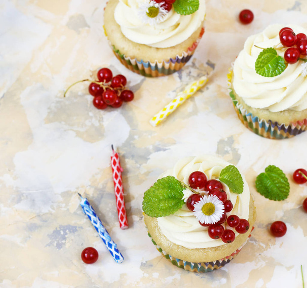 Gentle cupcake with cream and berries nd a candle a light background - 写真・画像