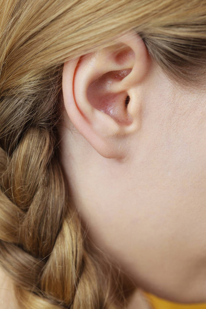 Close up on female ear and braid hair - Fotó, kép