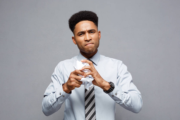 Концепція бізнес - портрет серйозні афро-американських бізнесмен, тримаючи на руках crumpling реферати.  - Фото, зображення