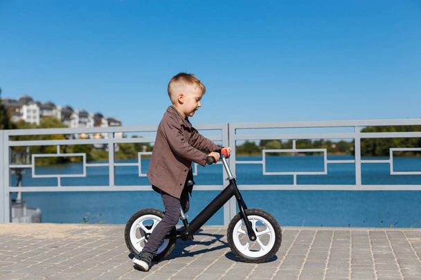 Szczęśliwy czterech lat chłopiec jazdy na rowerze bez pedałów na ba - Zdjęcie, obraz
