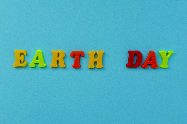 värikäs teksti "maa päivä" magneettisia kirjaimia sinisellä paperilla ba
 - Valokuva, kuva