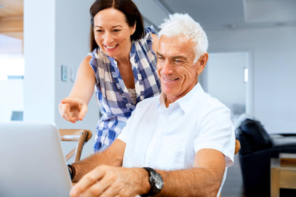 Happy modern mature couple working on laptop at home - Φωτογραφία, εικόνα
