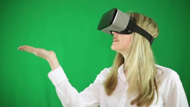 Una donna in occhiali di realtà virtuale, VR, su sfondo verde
. - Filmati, video