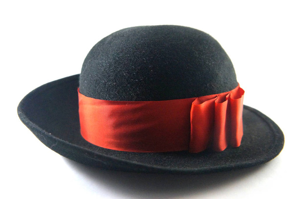 Black hat, hat, lady hat, felt hat, round hat, hat with ribbon, red ribbon, red bow, headpiece, red, white background, close-up, accessory, clothing, fashion, style. Headstock stock image. - Photo, Image