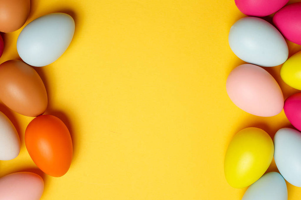 huevos de Pascua de colores sobre un fondo amarillo - Foto, Imagen