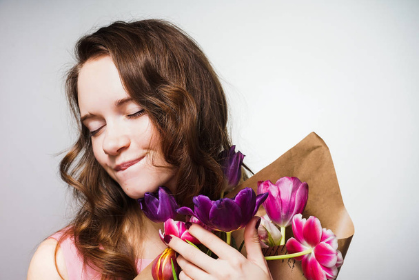 cute beautiful young woman holding a big bouquet of flowers, celebrating the world women's day, March 8 - Fotoğraf, Görsel