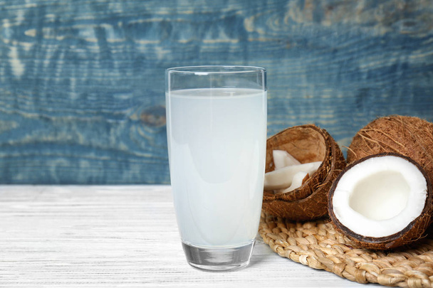 Glass of coconut water and fresh nuts on wooden table - Foto, Imagem