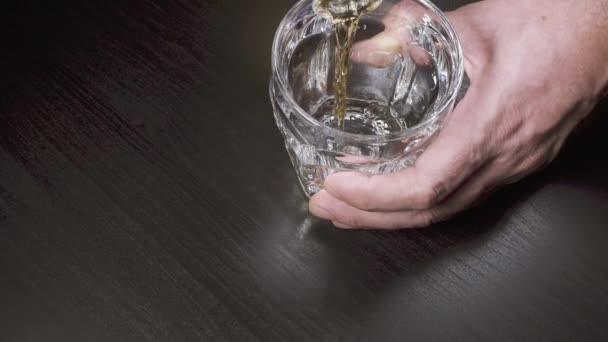 Lassú mozgás az ember önti whiskey, egy üveg felső nézetbe - Felvétel, videó