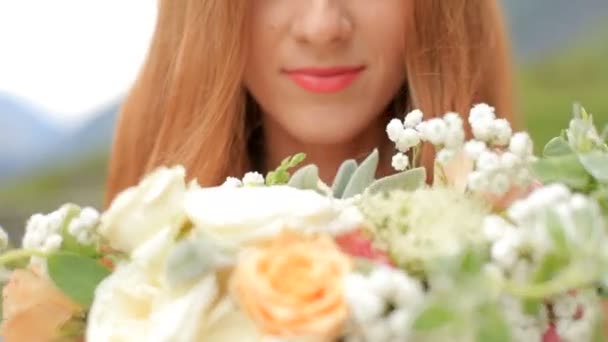 Beautiful red-haired bride dancing against the background of mountains. close-up - Záběry, video