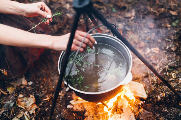  young woman cooking in forest outdoors - Fotó, kép