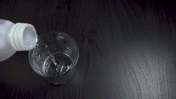Víz ömlött a műanyag tartály felülnézet-lassú mozgás - Felvétel, videó