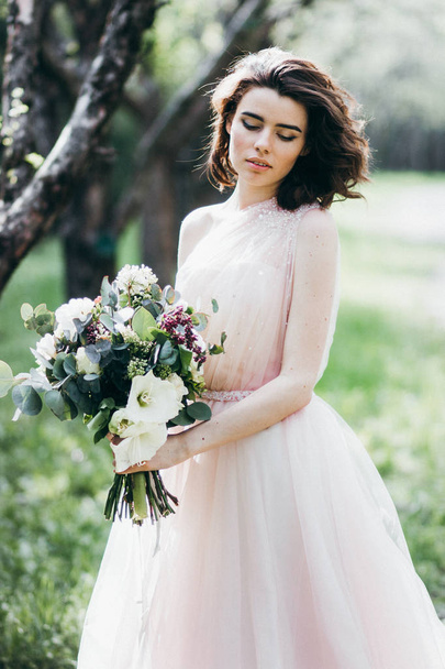 young  beautiful  bride holding flowers  outdoors - 写真・画像
