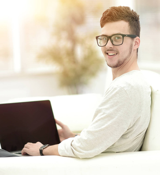modern young man working on laptop sitting in the living room. - 写真・画像