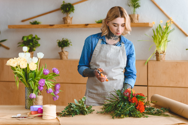 beautiful young woman arranging flowers in flower shop  - Fotografie, Obrázek