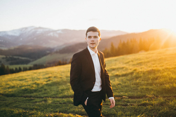 handsome  young groom  posing in mountains - Fotoğraf, Görsel