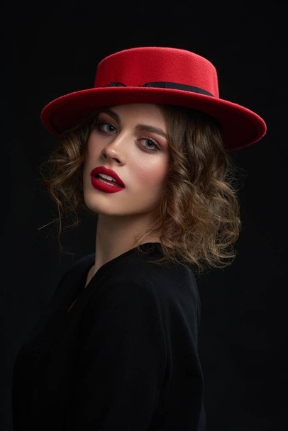 Studio portrait of young girl wearing red hat. - Fotó, kép