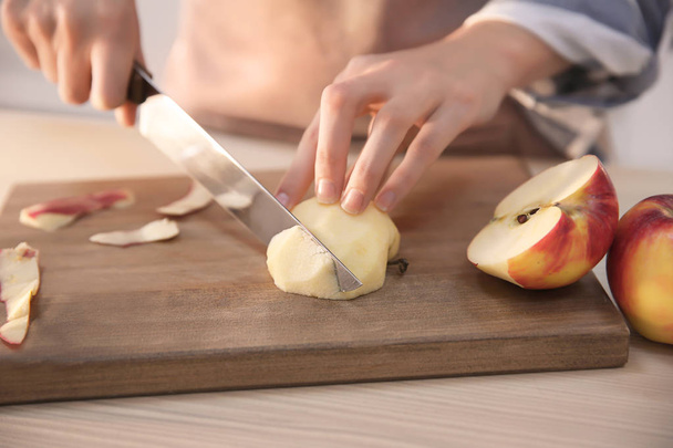 Frau schneidet reifen Apfel am Tisch - Foto, Bild