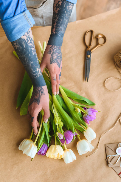 cropped shot of florist with tattoos arranging beautiful tulips at workplace - Φωτογραφία, εικόνα