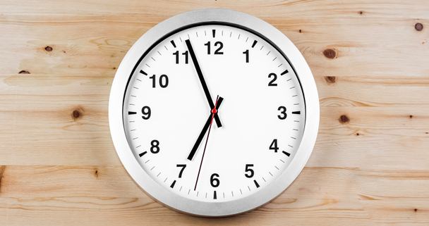 Son las siete en punto, hora de despertarse para desayunar, moderno reloj de pared con alarma metálica blanca sobre fondo de madera
  - Imágenes, Vídeo