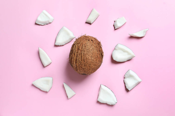 Whole coconut with pieces on color background - Foto, afbeelding