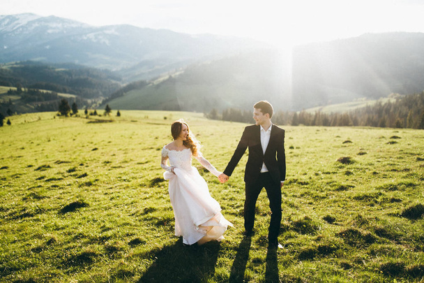 young couple of newlyweds holding hands outdoors - Фото, зображення