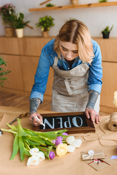 young florist in apron writing word open on board in flower shop - Photo, Image