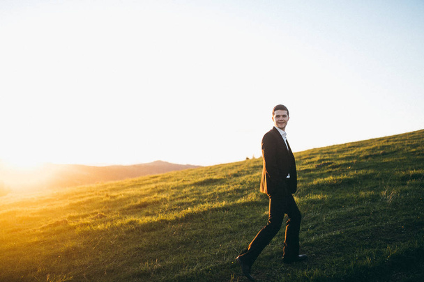 handsome  young groom  posing in mountains - Foto, Bild
