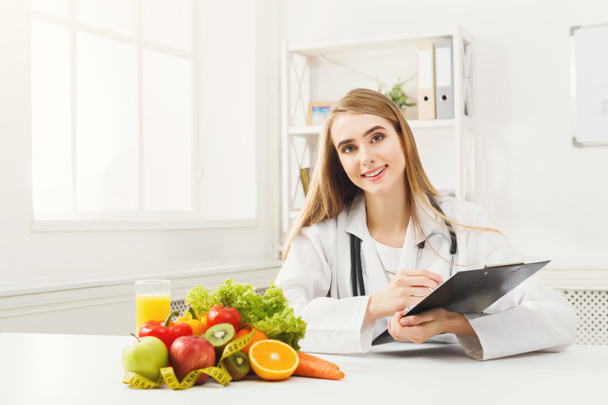 Escritorio nutricionista con fruta y cinta métrica
 - Foto, imagen