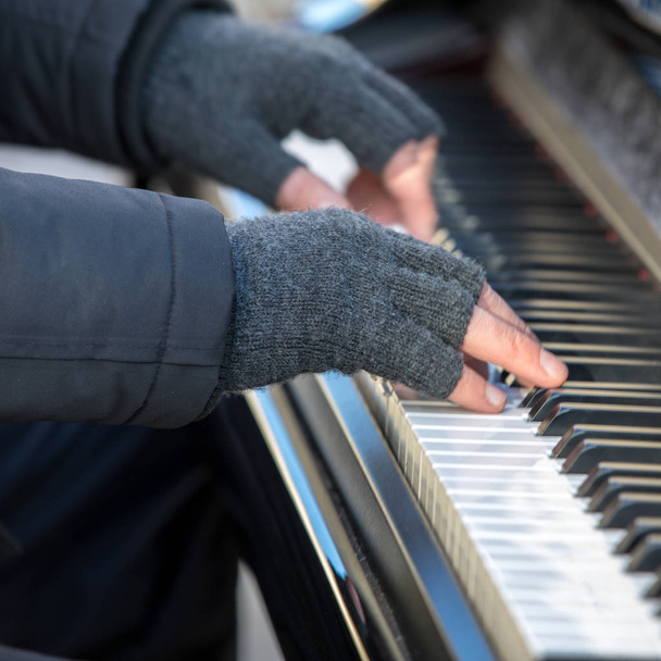 ピアニストは冬で外ピアノを弾きます - 写真・画像