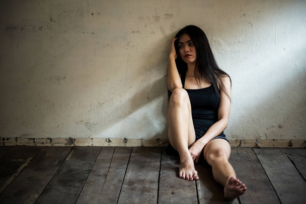 Стрессовая женщина сидит в темной комнате
 - Фото, изображение