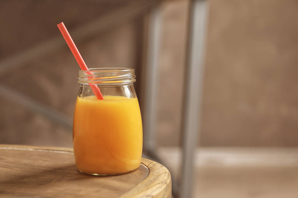 Jar of orange juice on wooden table - Fotoğraf, Görsel