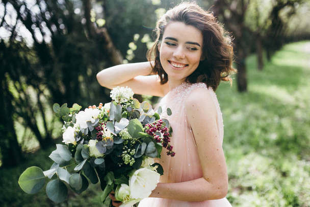 young  beautiful  bride holding flowers  outdoors - Foto, Imagen
