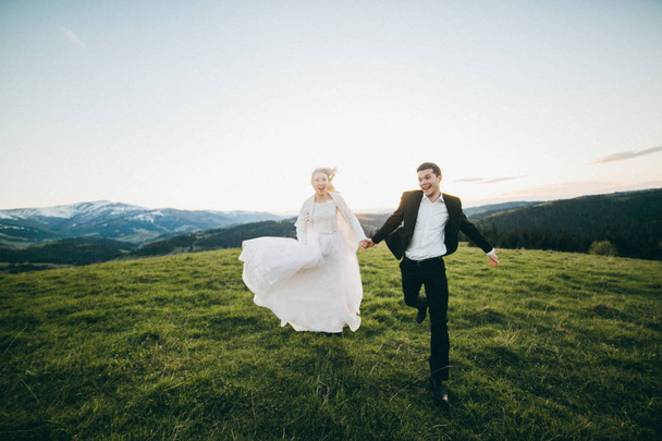 young couple of newlyweds running  in mountains - Foto, Bild