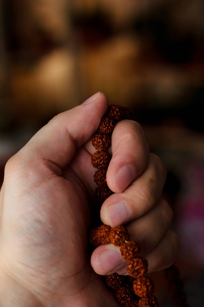 Main de prière tenant des perles ou chapelet rudraksha
 - Photo, image
