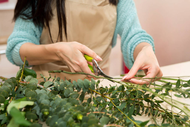 hands girls cutting scissors alive greens for flowers in a flower shop - Fotografie, Obrázek