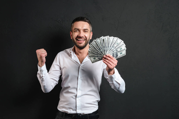 Emotional businessman holding money. - Foto, immagini