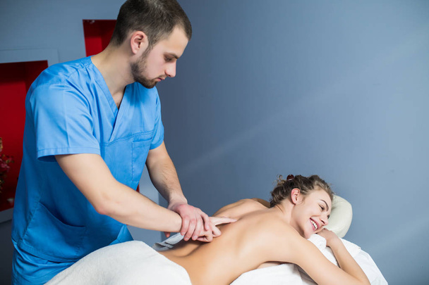 Beautiful young woman relaxing with hand massage at beauty spa - Zdjęcie, obraz