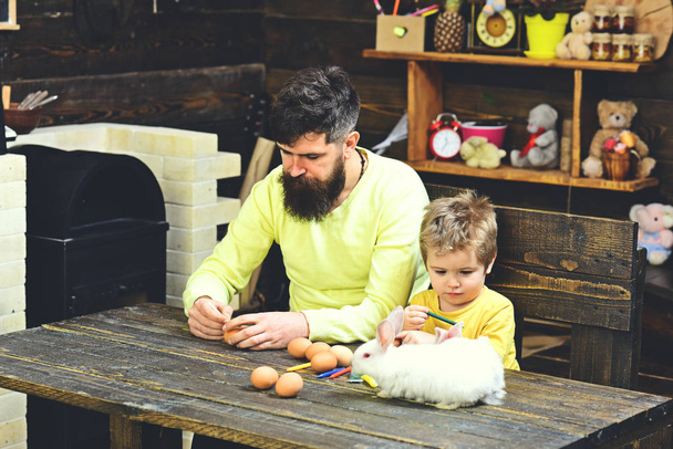 Father and kid painting Easter eggs. - Foto, Bild