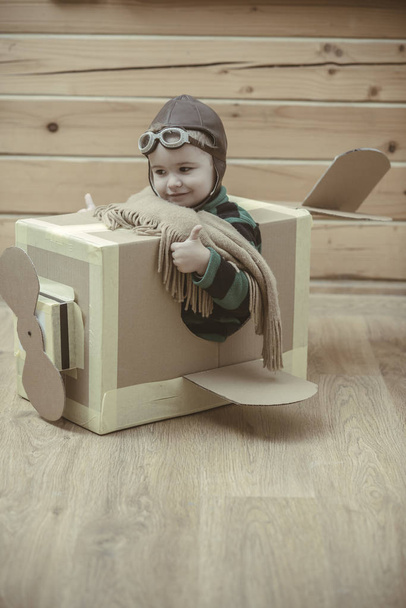 Brave dreamer boy playing with a cardboard airplane - Fotó, kép