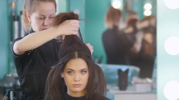 Maquiagem artista no salão de beleza faz estilo de cabelo para menina atraente, close-up
 - Filmagem, Vídeo