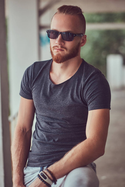 A handsome redhead male with a stylish haircut and beard dressed - Foto, immagini