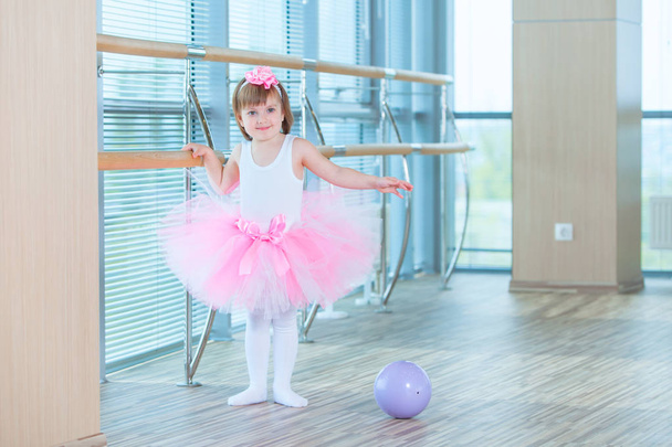 Little ballerina girl in a pink tutu. Adorable child dancing classical ballet in a white studio. Children dance. Kids performing. Young gifted dancer in a class. Preschool kid taking art lessons. - Φωτογραφία, εικόνα