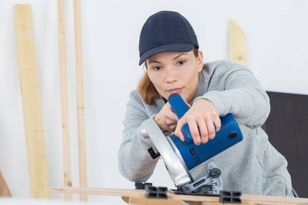 woman carpenter using circular saw - Fotó, kép