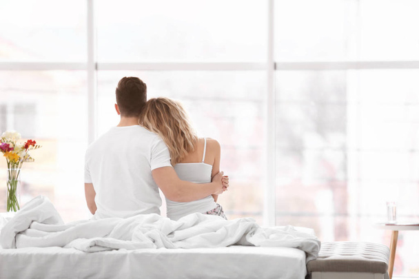 若いカップルが自宅のベッドで抱いて - 写真・画像