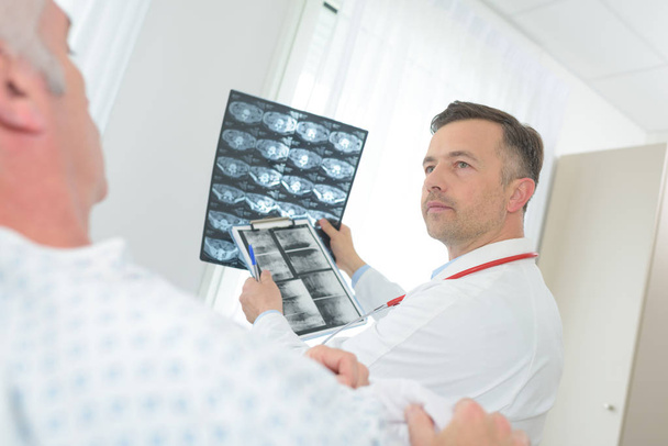 Γιατρός εξετάζει εικόνα ακτινογραφία στο δωμάτιο του νοσοκομείου - Φωτογραφία, εικόνα
