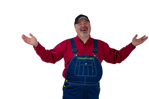 Laughing happy man in dungarees raising his arms - Foto, afbeelding
