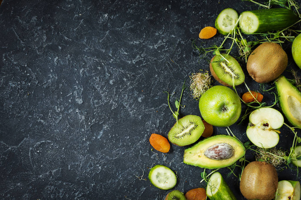 İçin pişirme smoothie malzemeler. Organik yeşil sebze ve meyveler siyah taş zemin üzerine. Kopya alanı, üstten görünüm - Fotoğraf, Görsel