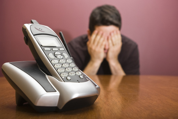 Man hides his face waiting for the phone to ring - Photo, Image