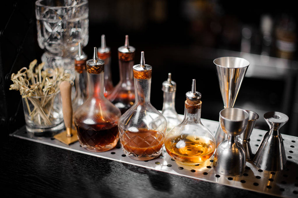 Set of bar equipment and bottles with syrups on the bar counter - Fotó, kép